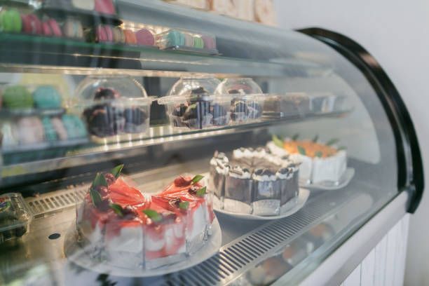 A freezer room showcasing various cakes cut in slices.